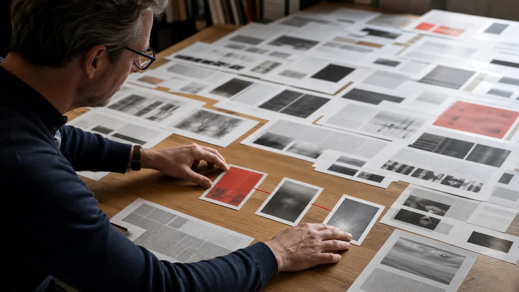 AI-generated conceptual photographic illustration of an editor selecting three image cards from printed source material